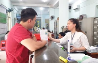 Công chức tư pháp - hộ tịch UBND phường 3, quận Gò Vấp hướng dẫn thủ tục khai sinh và nhập hộ khẩu. Ảnh: TRÚC PHƯƠNG