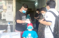 Nhân viên y tế tại trạm y tế lưu động ở phường 7, quận Gò Vấp đang xét nghiệm nhanh cho F0. Ảnh: N.HIỀN
