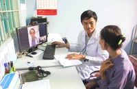 Bác sĩ Trạm y tế xã Tân Nhựt (huyện Bình Chánh, TP.HCM) khám cho bệnh nhân bằng phần mềm hội chẩn từ xa với bệnh viện tuyến trên. Ảnh: NVCC
