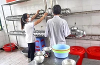 Ông P đang phụ điều dưỡng sắp xếp chén bát lên kệ. Ảnh: TRẦN NGỌC