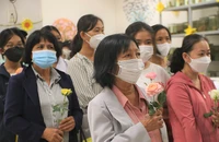 Bà Tăng Thị An Nhi cầm đóa hoa hồng để tri ân người em đã hiến xác cho khoa học. Ảnh: THẢO PHƯƠNG