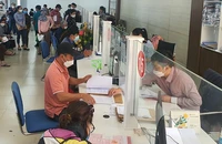Một số thủ tục hành chính hiện nay vẫn yêu cầu người dân phải có giấy xác nhận nơi cư trú thay cho sổ hộ khẩu. Ảnh: TẤN VIỆT