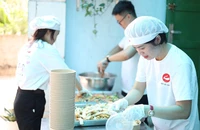 Chị Lê Tường Vy chuẩn bị các suất ăn cho bệnh nhi. Ảnh: THẢO PHƯƠNG