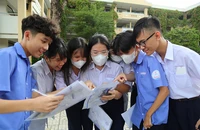 Học sinh tham dự kỳ thi tuyển sinh vào lớp 10 tại TP.HCM dò bài sau khi rời phòng thi. Ảnh: HOÀNG GIANG