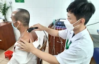 Một bệnh nhân đang được điều trị bằng điện xung kết hợp siêu âm. Ảnh: TRẦN NGỌC