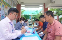 Phụ huynh có con vào lớp 1 đến Trường Tiểu học Lương Thế Vinh, quận Gò Vấp làm hồ sơ nhập học vào ngày 5-7. Ảnh: NGUYỄN QUYÊN