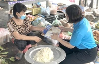 Người dân tìm hiểu chính sách BHXH tự nguyện để tham gia nhằm hưởng lương hưu khi về già. Ảnh: VIẾT LONG