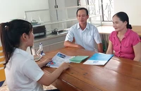 Cán bộ BHXH Việt Nam đang tư vấn về BHXH tự nguyện cho người dân. Ảnh: VIẾT LONG