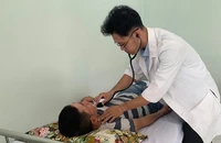 BS Ngô Minh Nhật đang khám bệnh tại Trạm y tế xã Bình Hưng, huyện Bình Chánh, TP.HCM. Ảnh: TRẦN NGỌC