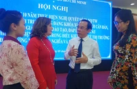 Bí thư Thành ủy TP.HCM trò chuyện với hiệu trưởng các trường bên lề hội nghị. Ảnh: NGUYỄN QUYÊN