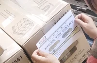 Người của vựa nông sản cùng các công nhân dán tem khoai tây Đà Lạt lên thùng khoai tây Trung Quốc để bàn giao cho khách. Ảnh trong bài: MINH HẬU - TỰ SANG