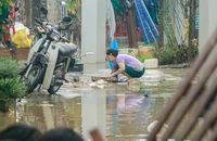 Người dân Nha Trang (tỉnh Khánh Hòa) dọn dẹp bùn đất sau bão lũ. Ảnh: XUÂN HOÁT