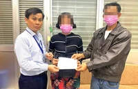 Anh Lê Minh Hiển (trái) trao danh sách mạnh thường quân hỗ trợ viện phí cho vợ chồng ông M, môt trong những bệnh nhân nghèo đang chữa trị tại BV. Ảnh: TRẦN NGỌC 