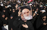 Một người cầm áp phích của Cố lãnh tụ tối cao Iran - ông Ayatollah Khomeini trong một cuộc biểu tình ủng hộ chính phủ ở thủ đô Tehran (Iran) ngày 23-9. Ảnh: AP