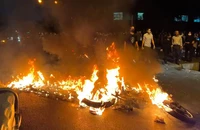Người biểu tình ở thủ đô Tehran đốt xe cảnh sát trong cuộc biểu tình ngày 19-9. Ảnh: AFP