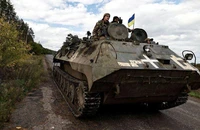 Lính Kiev lái xe bọc thép di chuyển tại tỉnh Donetsk (vùng Donbass, Ukraine). Ảnh: REUTERS