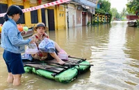 Nước lũ bủa vây phố cổ Hội An, người dân chèo bè đi mua đồ ăn sáng.