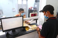 Công an TP.HCM làm thủ tục cấp biển số xe cho người dân. Ảnh: MINH VƯƠNG