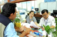 Cán bộ tư pháp phường Bình Hưng Hoà A, quận Bình Tân tất bật với các thủ tục sao y, trích lục cho người dân. Ảnh: LÊ THOA