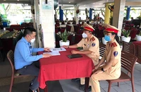 Đội CSGT Tân Sơn Nhất cho chủ quán nhậu ký cam kết. Ảnh: MINH VƯƠNG