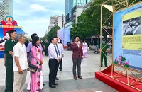 Các đại biểu tham quan triển lãm ảnh. Ảnh: NGUYỄN BÍCH