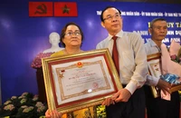 Bí thư Thành uỷ TP.HCM Nguyễn Văn Nên trao quyết định truy tặng danh hiệu "Bà Mẹ Việt Nam anh hùng" cho gia đình Mẹ Nguyễn Thị Mường. Ảnh: NGUYỆT NHI