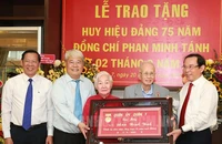Bí thư Thành uỷ TP.HCM Nguyễn Văn Nên cùng lãnh đạo TP, lãnh đạo quận 7 trao tặng huy hiệu cho ông Phan Minh Tánh. Ảnh: Website Thành uỷ TP.HCM