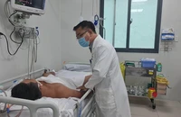 Bác sĩ BV Chợ Rẫy đang thăm khám cho bệnh nhân ngộ độc botulinum. Ảnh: NGUYỄN CHÂU
