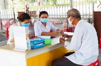 Một người dân đang lãnh lương hưu tại điểm chi trả lương hưu. Ảnh: VIẾT LONG