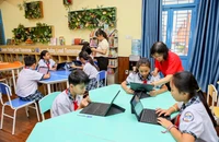 Cô Nguyễn Thị Ánh Nga (Phó Hiệu trưởng Trường Tiểu học Lê Đức Thọ, quận Gò Vấp) cùng các học sinh trong phòng thư viện thông minh. Ảnh: NGUYỆT NHI