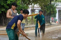 Người dân miền Trung tất bật lau dọn bùn đất, sửa sang nhà cửa sau lũ