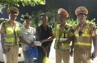 2 em đang đi bộ trên quốc lộ để về quê thì được CSGT hỗ trợ