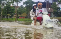 Mưa lớn dồn dập, lũ dâng cao, người dân Huế vội vã đưa xe đi tránh lũ