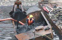 Cảnh công nhân ngâm mình nạo vét sông Tô Lịch dưới tiết trời mưa rét 