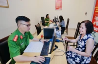 Dân cười tươi khi làm thủ tục hành chính ở công an phường ngày đầu vận hành chính quyền 2 cấp