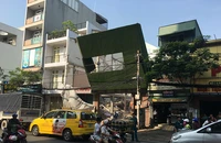 Biển quảng cáo đổ đè trụ điện ở công trình đang tháo dỡ