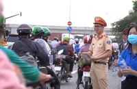 CSGT TP.HCM phát nón bảo hiểm, nước uống cho người dân về quê