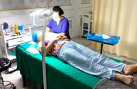 Nữ lao công đang thực hiện căng da mặt cho khách tại cơ sở Viện thẩm mỹ Kangzin Đà Nẵng. Ảnh: MT.