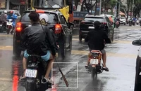 Ba thanh niên mang dao đi trên đường gây hoang mang cho người dân. Ảnh: CA.
