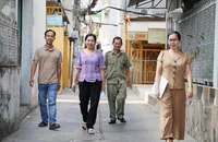 Bà Mai Thị Lệ, Trưởng khu phố 16, phường Bình Hưng Hòa A, quận Bình Tân (thứ hai từ trái sang) cùng cán bộ khu phố đi phổ biến kết quả sắp xếp khu phố, ấp đến người dân địa phương. Ảnh: THUẬN VĂN