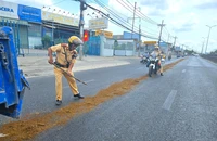 Người dân trượt té vì vệt nhớt, CSGT Tân Túc dang nắng rải cát xuống đường