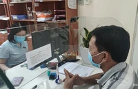 Người dân đến cơ quan BHXH quận 12 thực hiện thủ tục hành chính liên quan đến BHXH. Ảnh: NGUYỄN HIỀN