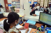 Cán bộ UBND quận Tân Bình (TP.HCM) đang hỗ trợ người dân sao y sổ hộ khẩu. Ảnh: HUỲNH THƠ