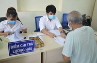 Người dân đang nhận lương hưu. Ảnh: VIẾT LONG