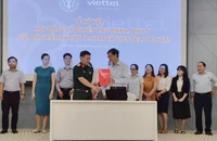 Đại diện BHXH và Viettel TP.HCM ký hợp đồng ủy quyền thu BHXH tự nguyện, BHYT hộ gia đình. Ảnh: NGUYỄN HIỀN 