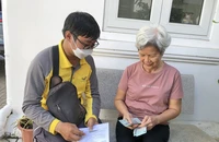 Nhân viên bưu điện chi trả lương hưu bằng tiền mặt tại nhà cho người hưởng lương hưu. Ảnh: TM