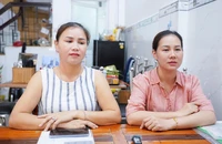 Bà Thanh Hiền (áo hồng) cùng chị ruột hơn 40 năm qua cùng sử dụng một tờ giấy khai sinh. Ảnh: THUẬN VĂN