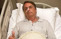 Tổng thống Brazil Jair Bolsonaro giơ ngón tay cái trong khi đang nằm viện do chứng tắc nghẽn đường ruột ở Sao Paulo, Brazil ngày 3-1. 