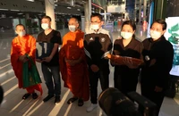 Huấn luyện viên Kiatisuk Senamuang (giữa), các sư thầy, gia đình Duangpetch Promthep cùng di cốt của cậu tại sân bay quốc tế Suvarnabhumi, tỉnh Samut Prakan (Thái Lan). Ảnh: FACEBOOK