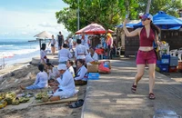 Một du khách nước ngoài tại bãi biển ở quận Kuta, tỉnh Bali (Indonesia). Ảnh: EPA